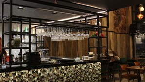 A bar area with a tiled backsplash, shelves with glassware, and wooden accents. - Quars Suite (Istanbul)