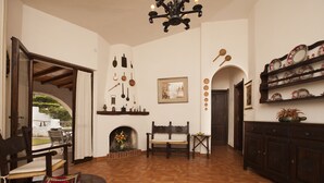 Un salón espacioso con chimenea, muebles de madera y objetos decorativos en las paredes.