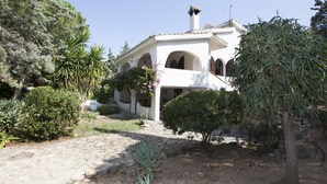 A white building with arched windows and a stone pathway leading to it. - Villa Wanda (Quartu Sant'Elena)