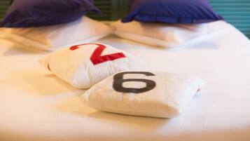 A bed with two pillows, one with a red number 2 and the other with a black number 6.