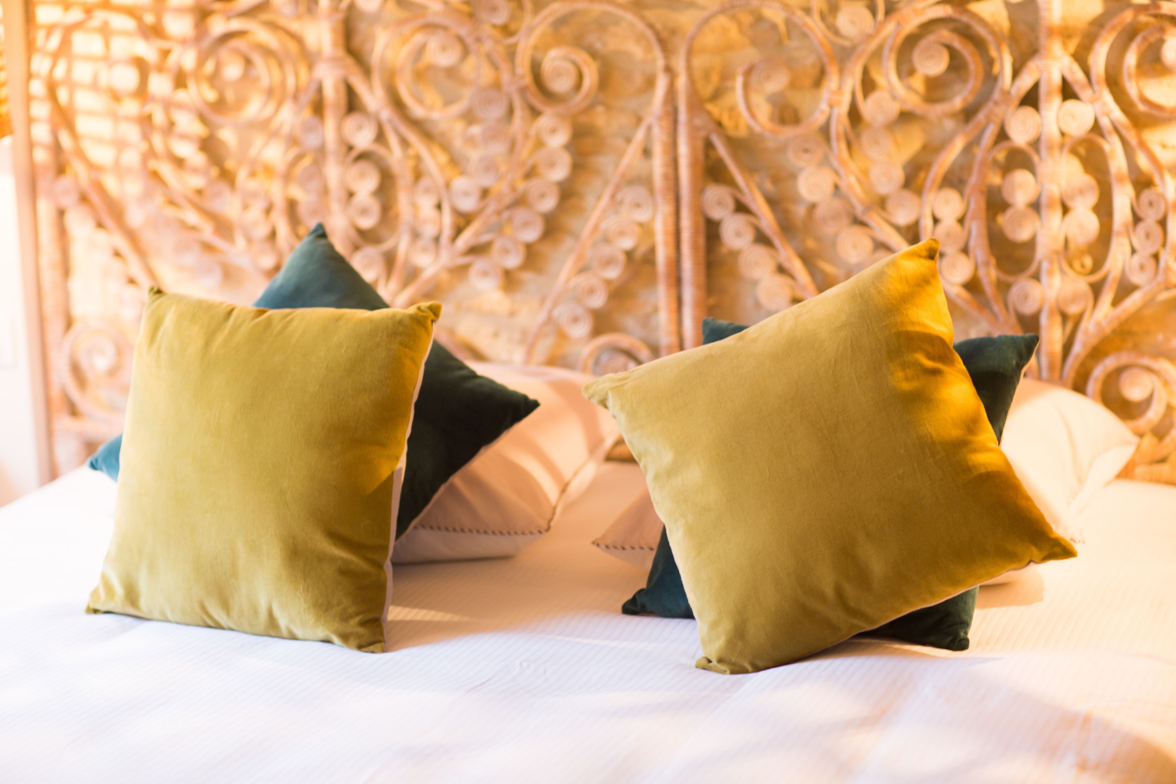 Una cama con cabecera metálica y almohadas.