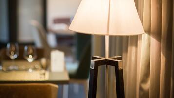 A floor lamp with a white lampshade in a room with a blurred background.