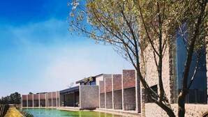 Een modern gebouw met een zwembad en een pad van stenen.