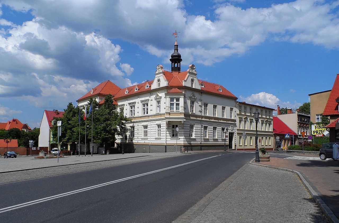 Ein historisches Gebäude mit roten Ziegeldach und einem markanten Turm.