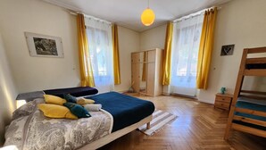 Une chambre à coucher avec un lit, des meubles en bois et un parquet à motifs en chevrons.