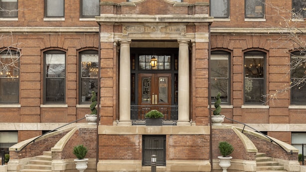 A brick building with a central entrance, large windows, and a staircase leading to the entrance. - Celeste of St Paul (St. Paul)