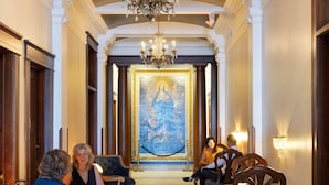 A grand hallway with ornate chandeliers, classical columns, and a large painting on the wall. - Celeste of St Paul (St. Paul)