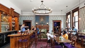 A traditional dining room with wooden furniture, a bar area, and a fireplace. - Celeste of St Paul (St. Paul)