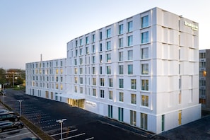 Stylish hotel building with a symmetrical facade and flat roof, featuring evenly spaced windows.