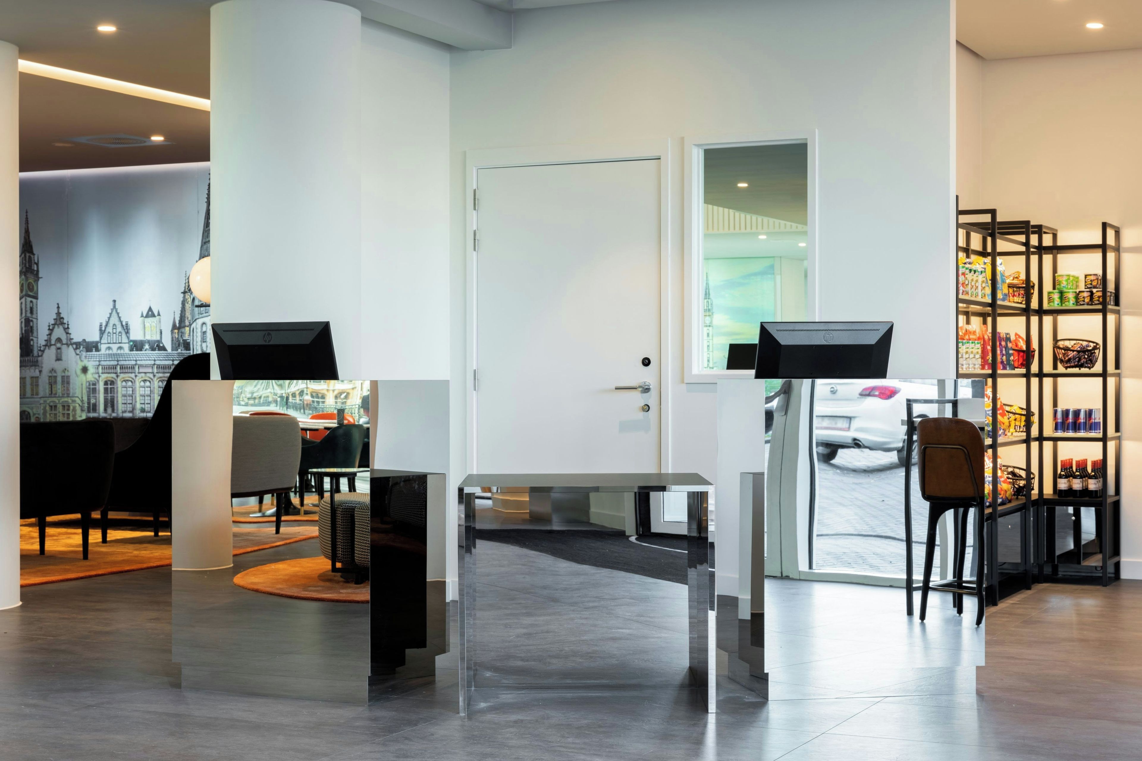 Un interior moderno con una mesa de recepción, zona de estar y exhibición de productos.