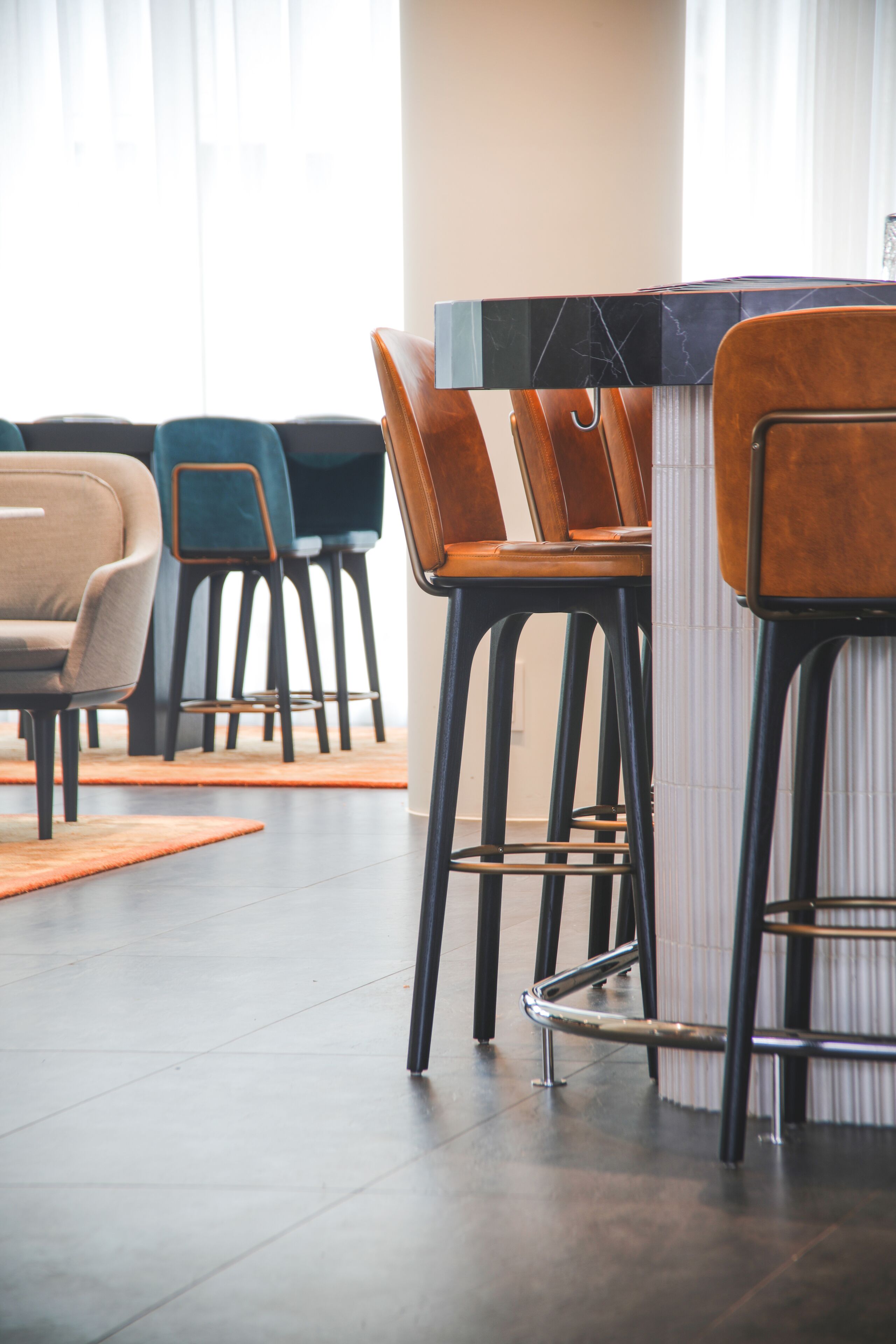 A modern dining area with high stools and a marble bar counter.