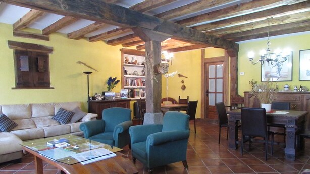 Una sala de estar acogedora con un sofá, dos sillones, una mesa de centro y un comedor con una mesa y sillas.