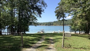 Une route privée mène à un lac où se trouvent un belvédère et un quai pour bateaux.