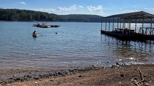 Un lac paisible, avec un quai et un espace de repos abrité.