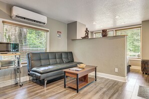 Una sala de estar moderna con un sofá de cuero, una mesa de centro y un equipo de aire acondicionado integrado.