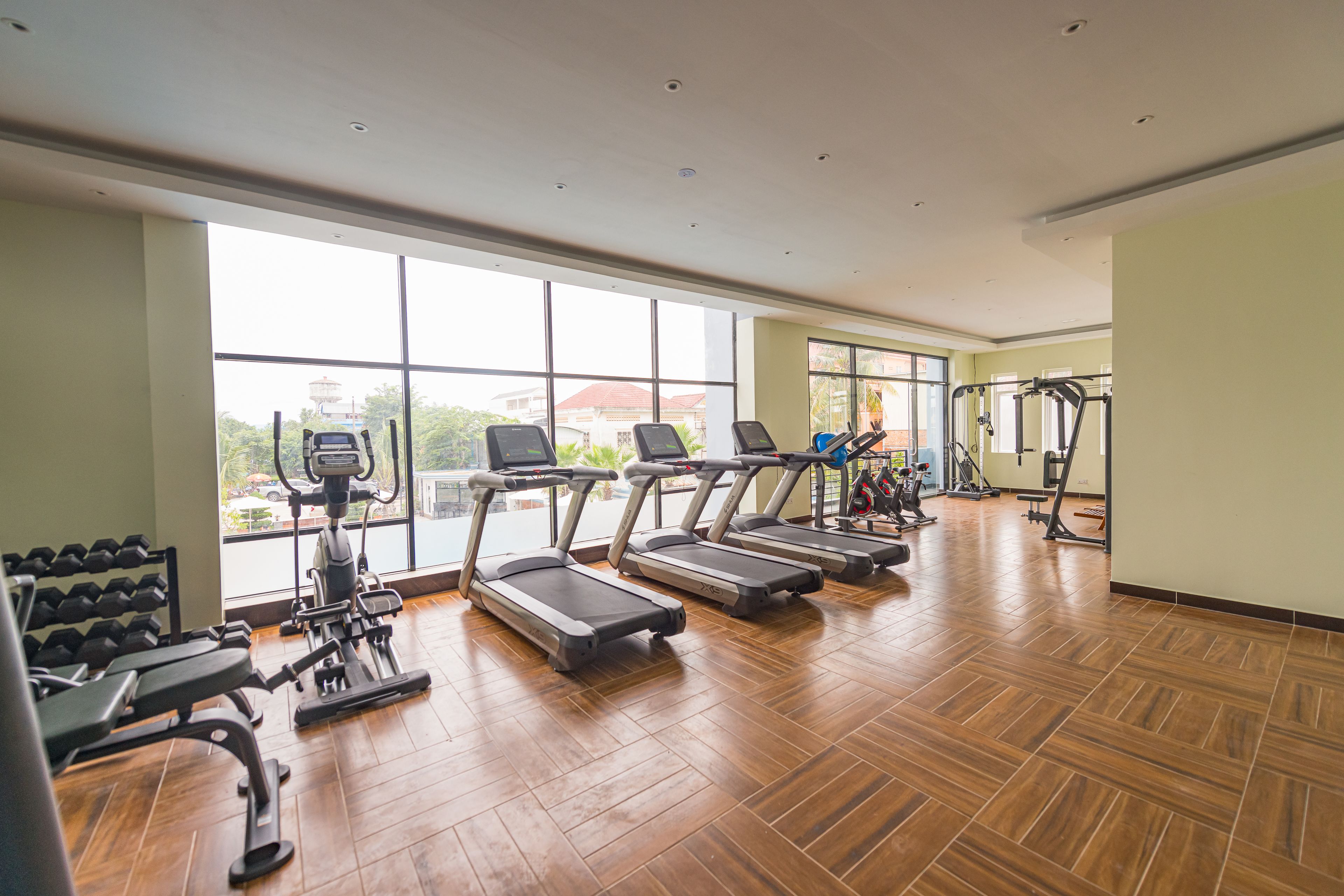 Un gimnasio con cintas de correr, mancuernas y máquinas de ejercicio.