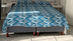 Una camera da letto con un letto, una ventola a soffitto, una finestra, una porta e un quadro appeso al muro.