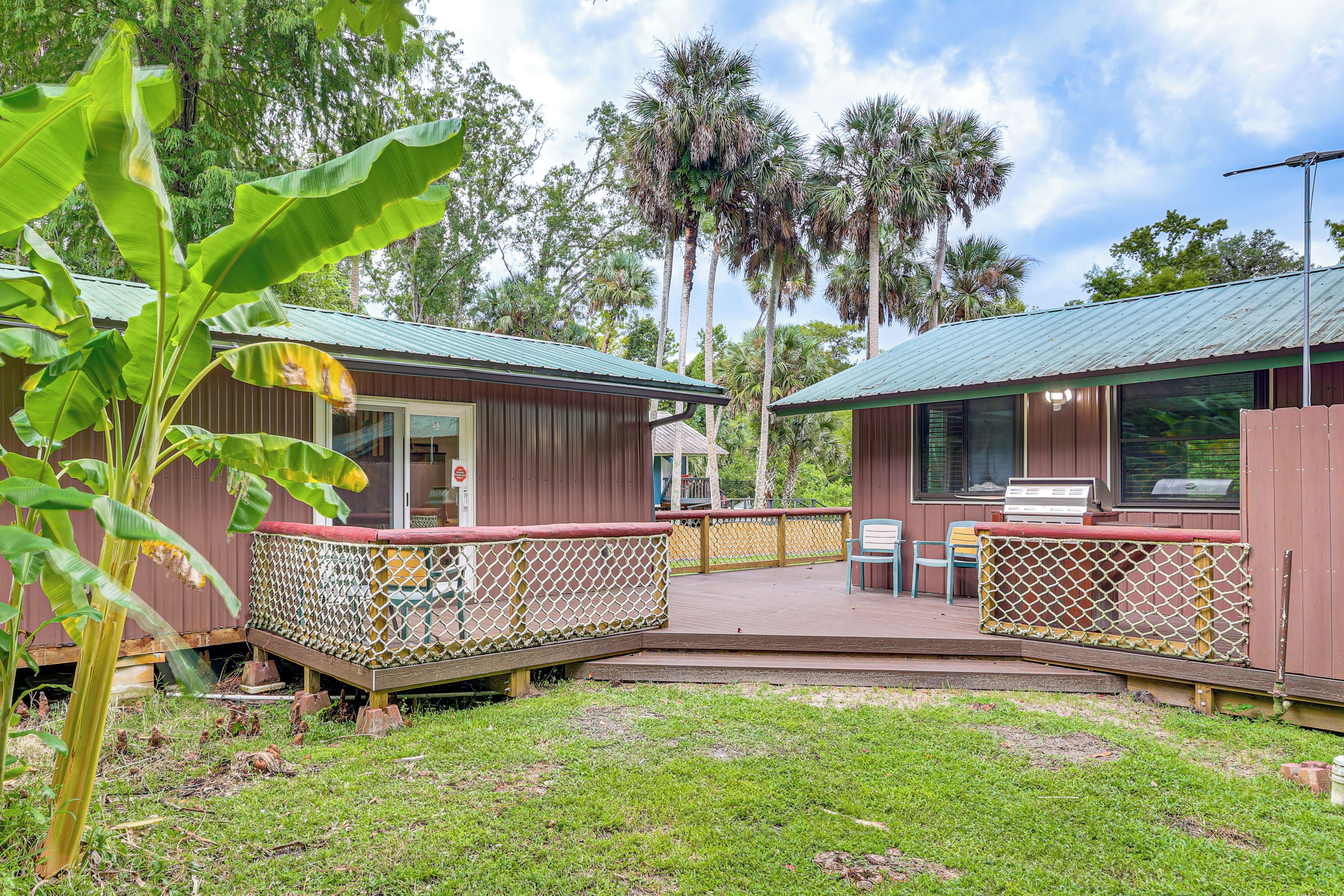A wooden cabin with a deck and a fenced patio area.