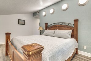 Ein Schlafzimmer mit einem hölzernen Bett, einem Nachttisch, einer Lampe und einem Bild an der Wand.