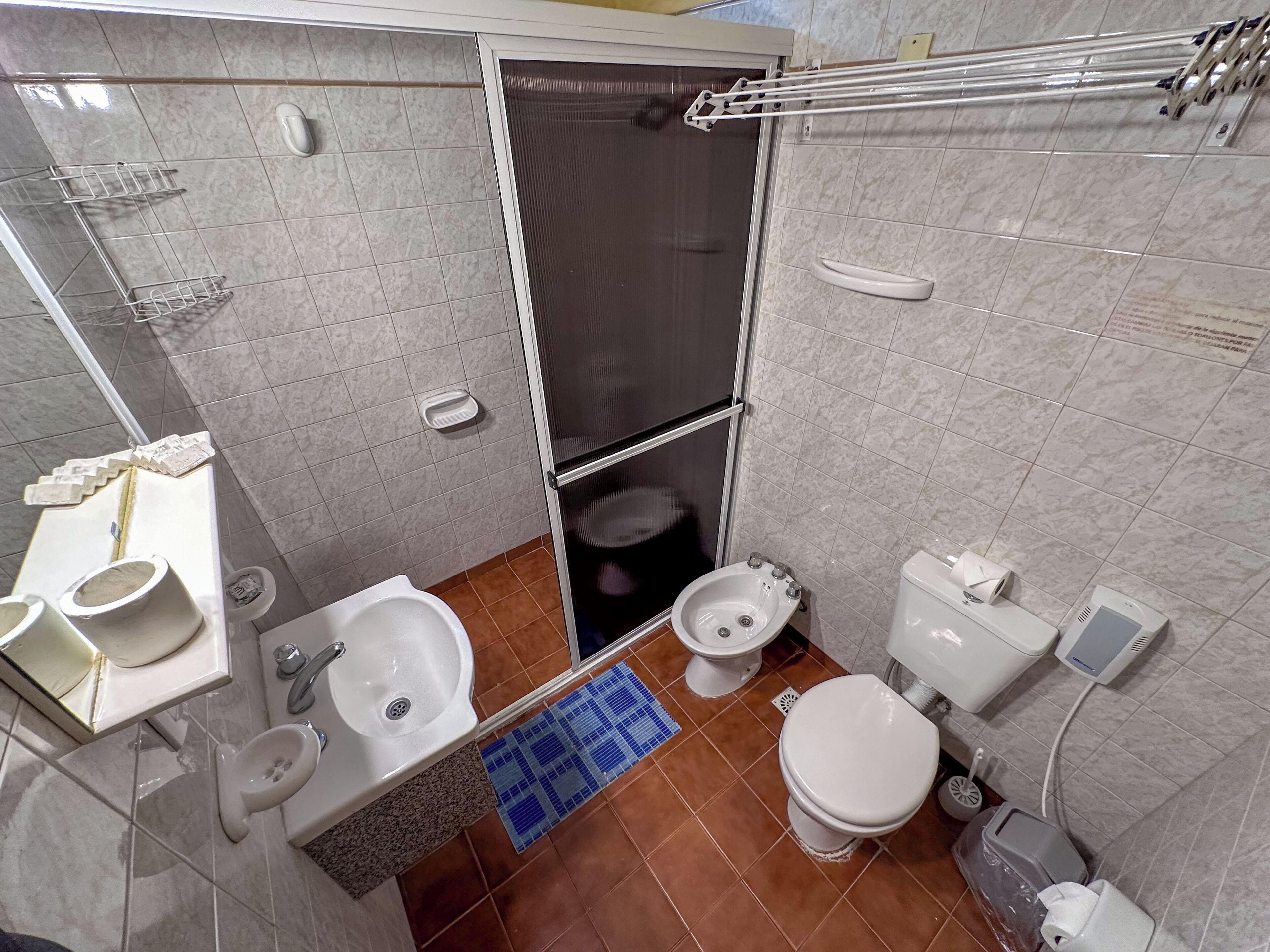 Un baño pequeño con inodoro, bidé y lavamanos.