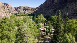 A mountainous landscape with a path leading to a building surrounded by trees.