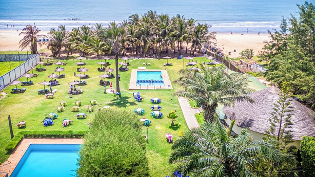 A resort with a pool, beach, and palm trees. - Kasumai Beach Resort (Serrekunda)