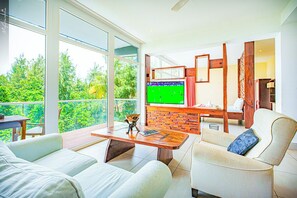 Panorama suite, uitzicht op oceaan | Woonruimte | Een televisie