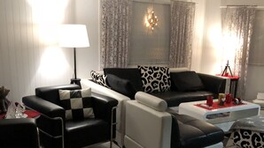 Un salon moderne avec un canapé, une table basse et une lampe.