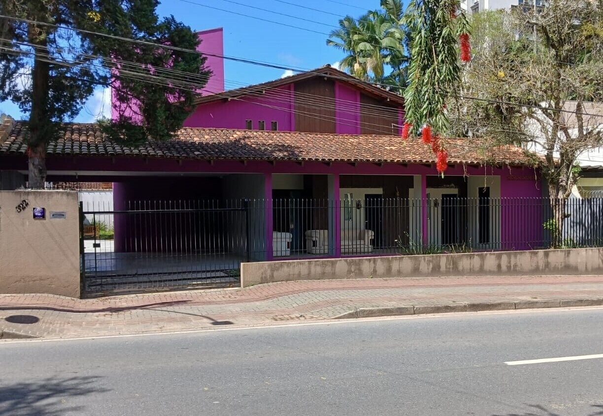 A two-story building with a purple facade and a tiled roof.