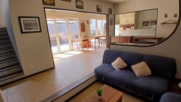 Een woonkamer met een bank, een salontafel en een trap die naar een balkon leidt.