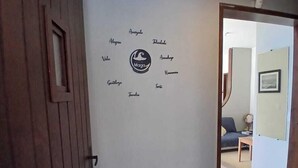 Een gang met een houten deur en een muur met een logo en namen.