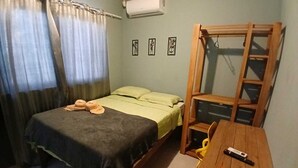 Een slaapkamer met een bed, een houten tafel en een ladder.