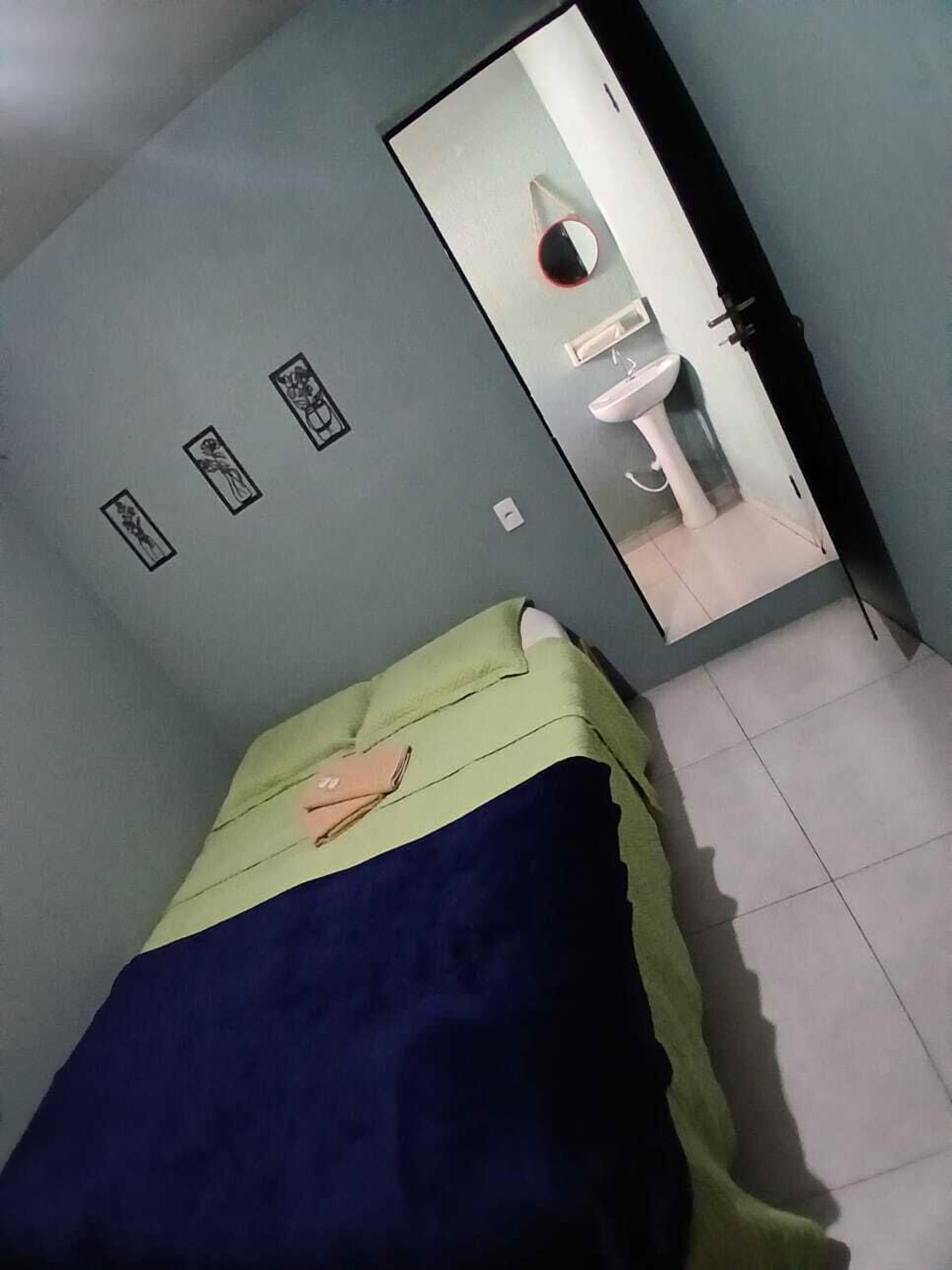A room with a bed, a mirror, and a sink.