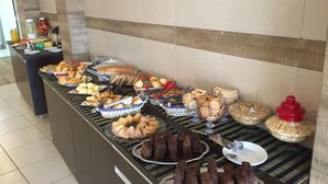 A buffet with various food items including bread, pastries, and desserts. - Village Plaza Hotel (Barbacena)