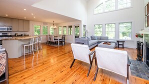 A spacious living area with a large sofa, a dining table, and a kitchen with modern appliances. - UNION PIER HOME WITH PRIVATE HEATED POOL! (Union Pier)