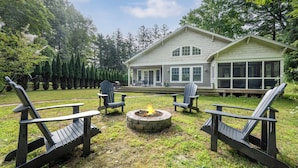 A house with a fire pit in the yard, surrounded by Adirondack chairs. - UNION PIER HOME WITH PRIVATE HEATED POOL! (Union Pier)