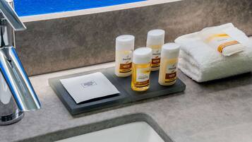 Una encimera de baño con artículos de aseo, como gel de ducha, champú y acondicionador.