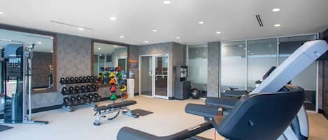 A modern gym with treadmills, dumbbells, and a variety of exercise equipment.