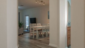 Un coin repas avec une table et des chaises, un téléviseur et une plante en pot.