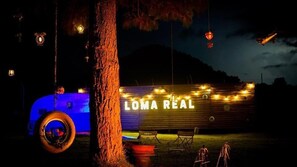 A rustic outdoor setting with a large sign reading "LOMA REAL" illuminated by string lights. - Hotel Loma Real Inn (Quetzaltenango)