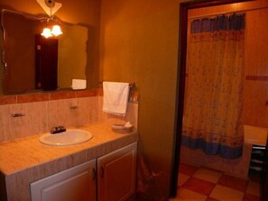 A bathroom with a sink, mirror, towel rack, and shower curtain. - Hotel Loma Real Inn (Quetzaltenango)
