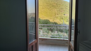 A balcony with a view of a green hillside.