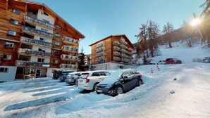 A multi-story hotel with balconies and a ski slope in the background. - Pracondu 2 001 - OUTDOOR & FUN  charming apartment (Haute-Nendaz)
