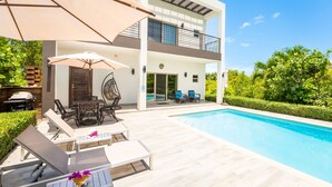 A modern two-story house with a swimming pool, outdoor seating, and a well-maintained garden. - SPECIAL DISC, 3BR PRIVATE VILLA, OCEAN VIEW, GREAT AMENITIES, STEPS TO THE BEACH (Long Bay Hills)