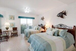 A hotel room with two beds, a balcony, and decorative fish wall art. - In The Heart of Cozumel (Cozumel)