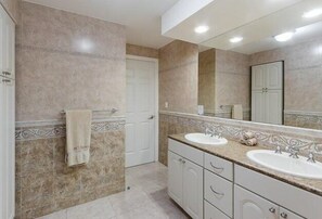 A bathroom with two sinks, a large mirror, and a towel hanging on the wall. - In The Heart of Cozumel (Cozumel)