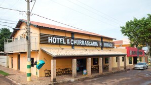Un hotel con un cartel que dice "HOTEL & CHURRASCARIA IRMAOS".