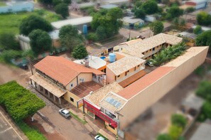 Un hotel con techo de tejas rojas, un depósito de agua y un letrero que dice 'HOTEL 2'.