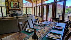 Un coin repas avec un mur en pierre, un canapé et une table mise pour le repas.