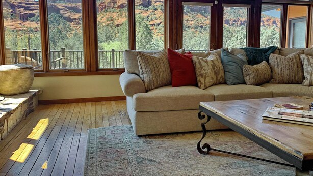 Un salon chaleureux avec une grande fenêtre donnant sur un paysage montagneux.